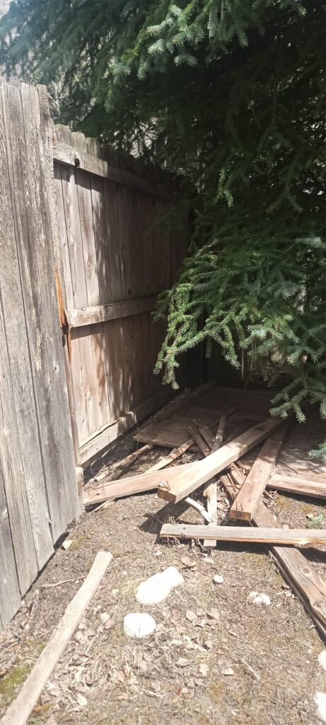 A cedar wood fence in need of repair.