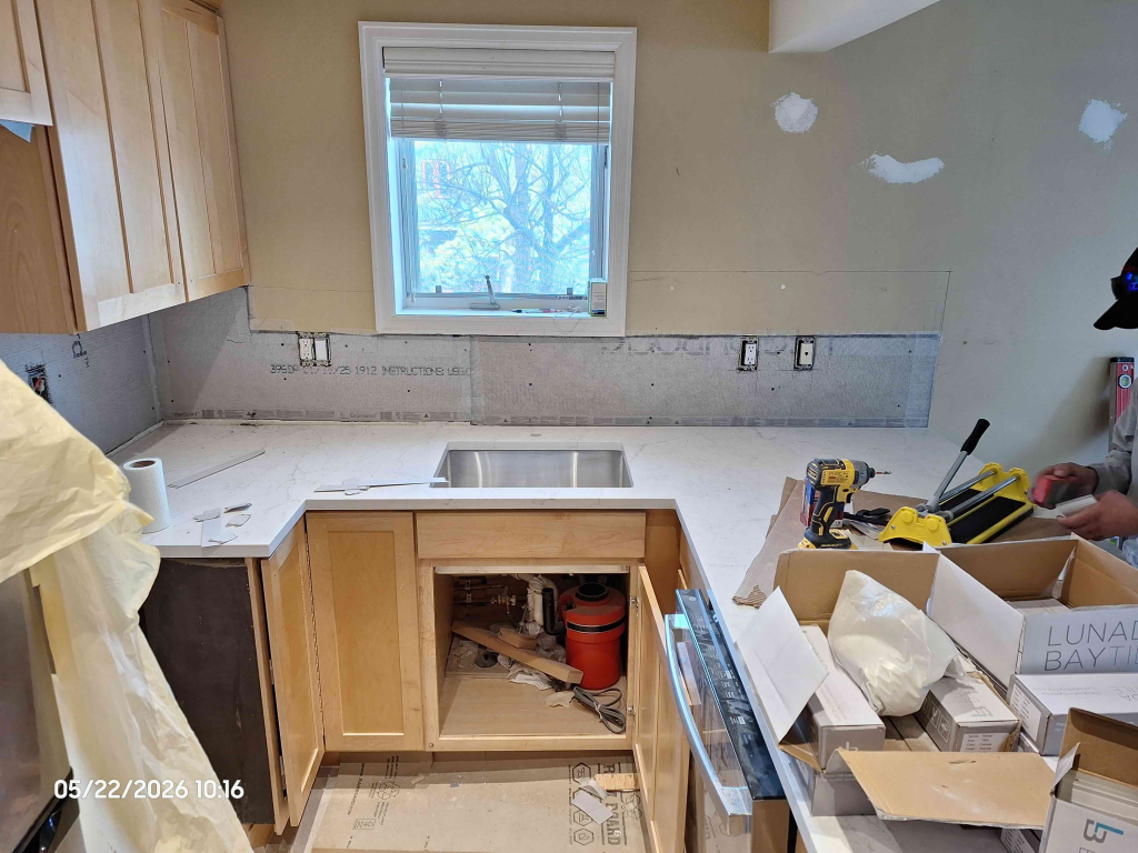 Kitchen remodel in progress at Aspen Square Condominiums featuring new quartz countertops, undermount sink, and backsplash preparation.